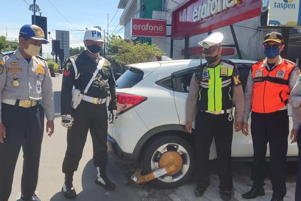 Petugas Gembok Mobil yang Parkir Sembarangan di Zona Terlarang