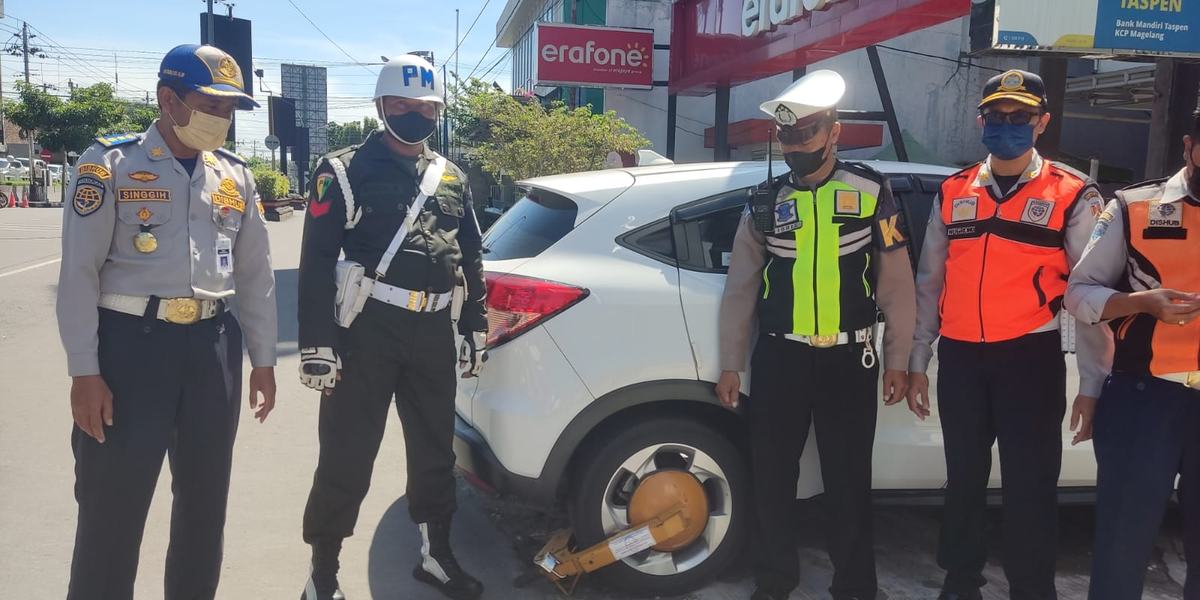 Petugas Gembok Mobil yang Parkir Sembarangan di Zona Terlarang